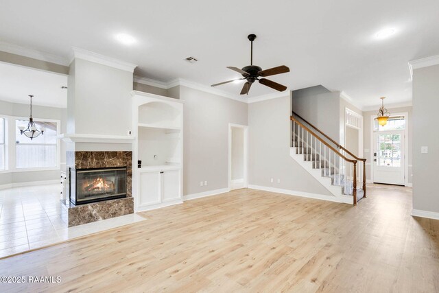 110 Yorkshire Cir, Lafayette, LA 70508 - unfurnished living room featuring light wood-style floors, stairway, baseboards, ornamental molding, and a tiled fireplace