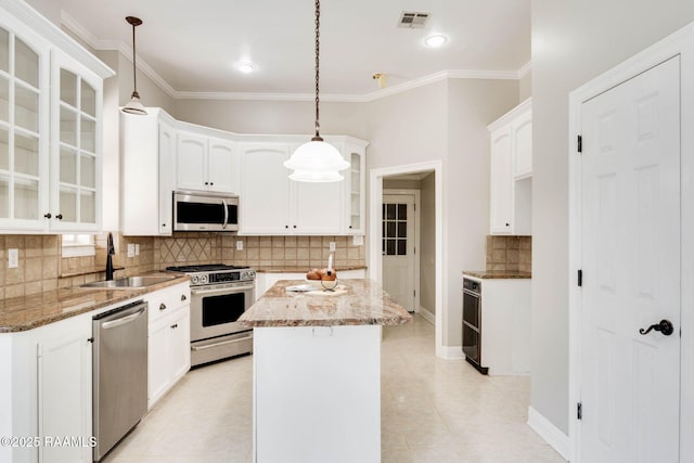 110 Yorkshire Cir, Lafayette, LA 70508 - kitchen with appliances with stainless steel finishes, a sink, glass insert cabinets, backsplash, and light stone countertops