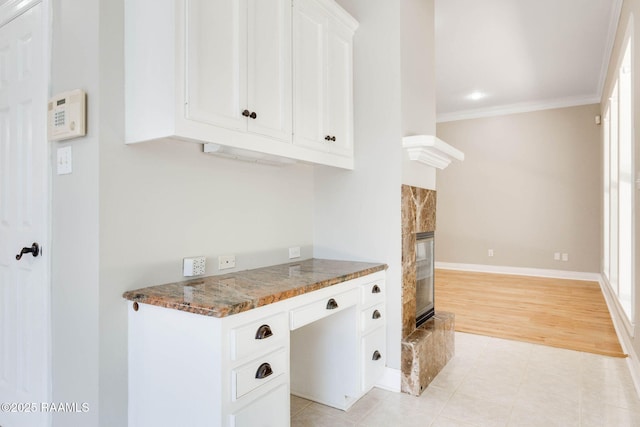 110 Yorkshire Cir, Lafayette, LA 70508 - kitchen featuring ornamental molding, white cabinets, a fireplace, baseboards, and light tile patterned flooring