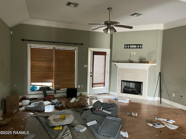 living room with crown molding, ceiling fan, a tile fireplace, and hardwood / wood-style flooring