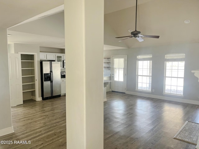 interior space featuring ceiling fan, a healthy amount of sunlight, dark wood-type flooring, and high vaulted ceiling