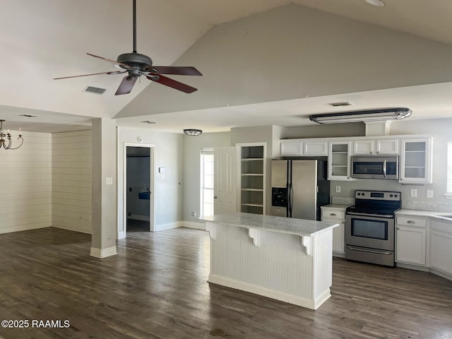 kitchen with a breakfast bar, a center island, dark hardwood / wood-style floors, stainless steel appliances, and white cabinets