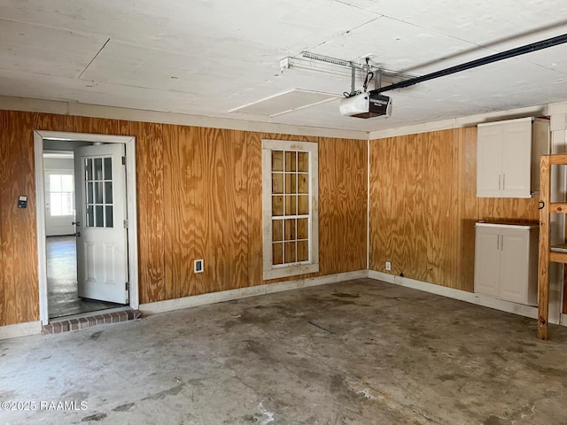 garage with a garage door opener and wood walls