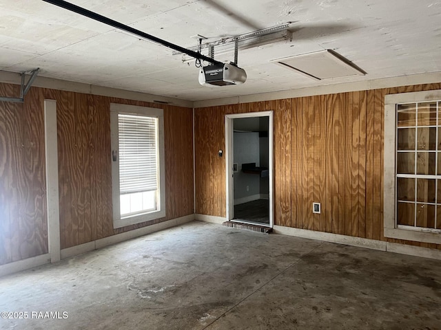 garage with a garage door opener and wooden walls