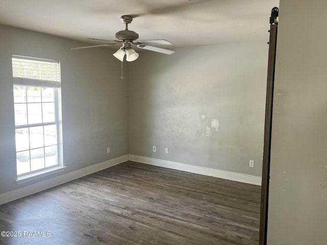 empty room with dark wood-type flooring, a wealth of natural light, and ceiling fan