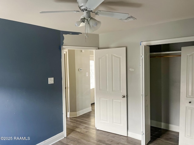 unfurnished bedroom with ceiling fan, wood-type flooring, and a closet