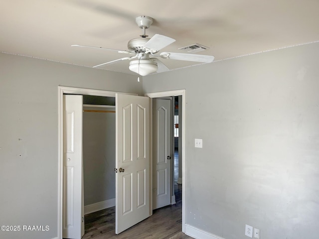 unfurnished bedroom featuring wood-type flooring, ceiling fan, and a closet