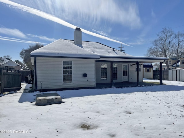 snow covered rear of property featuring a porch