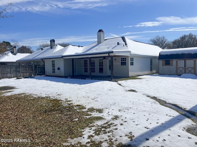 snow covered property with an outbuilding