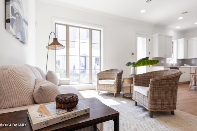 living room featuring crown molding and light wood-type flooring