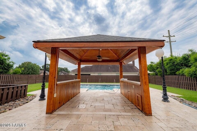 view of patio featuring a fenced in pool, a gazebo, and ceiling fan