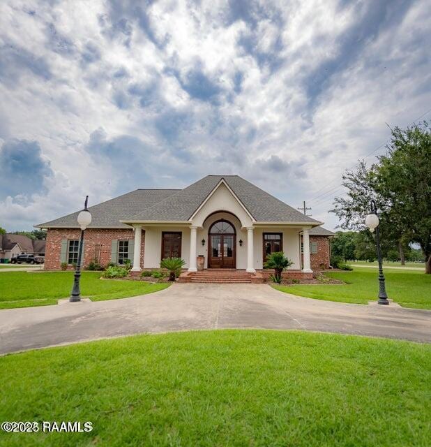 ranch-style home with a front lawn and french doors