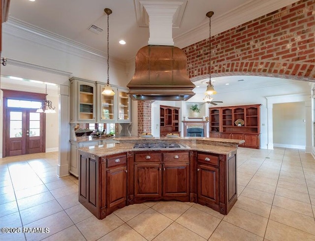 kitchen featuring stainless steel gas cooktop, custom exhaust hood, crown molding, decorative light fixtures, and ceiling fan