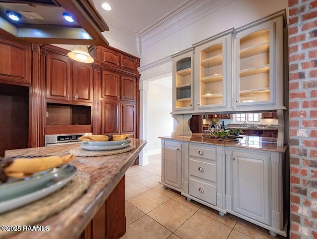 kitchen with ornamental molding, light stone countertops, light tile patterned flooring, and white cabinets