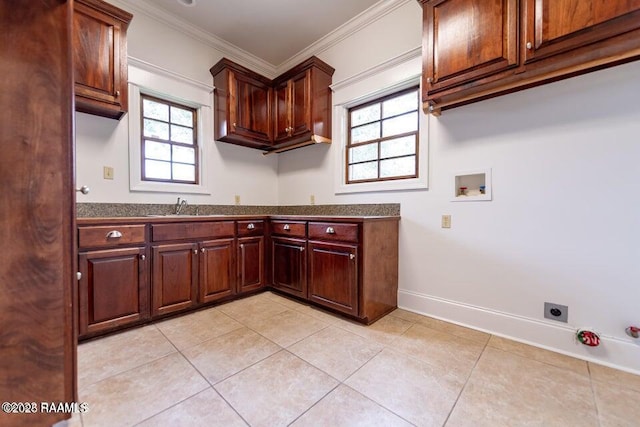 kitchen with ornamental molding, sink, and light tile patterned floors