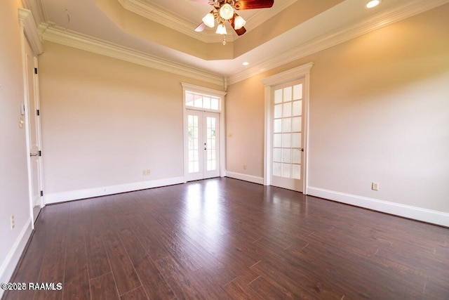 empty room with crown molding, dark wood-type flooring, ceiling fan, a raised ceiling, and french doors