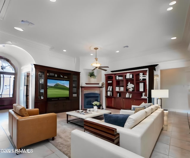 tiled living room with ornamental molding and ceiling fan