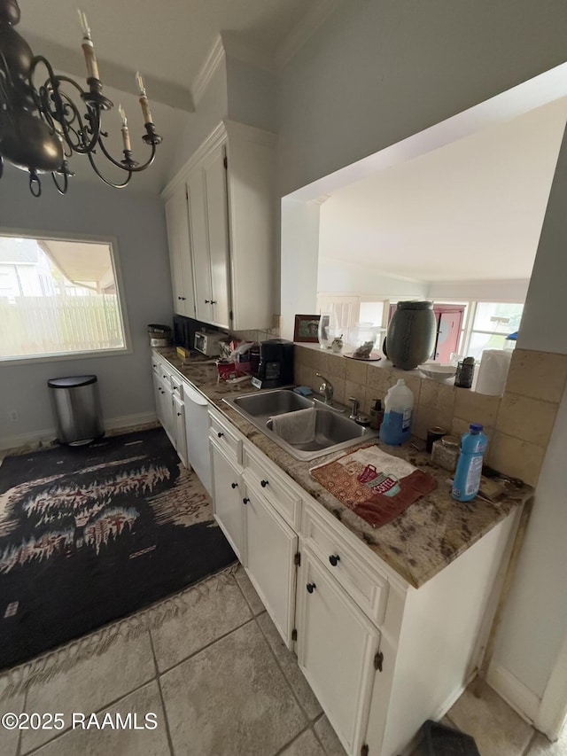 kitchen with sink, crown molding, a chandelier, white cabinets, and backsplash