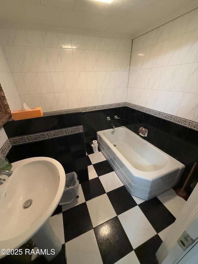 bathroom with sink, tile walls, and a bathtub