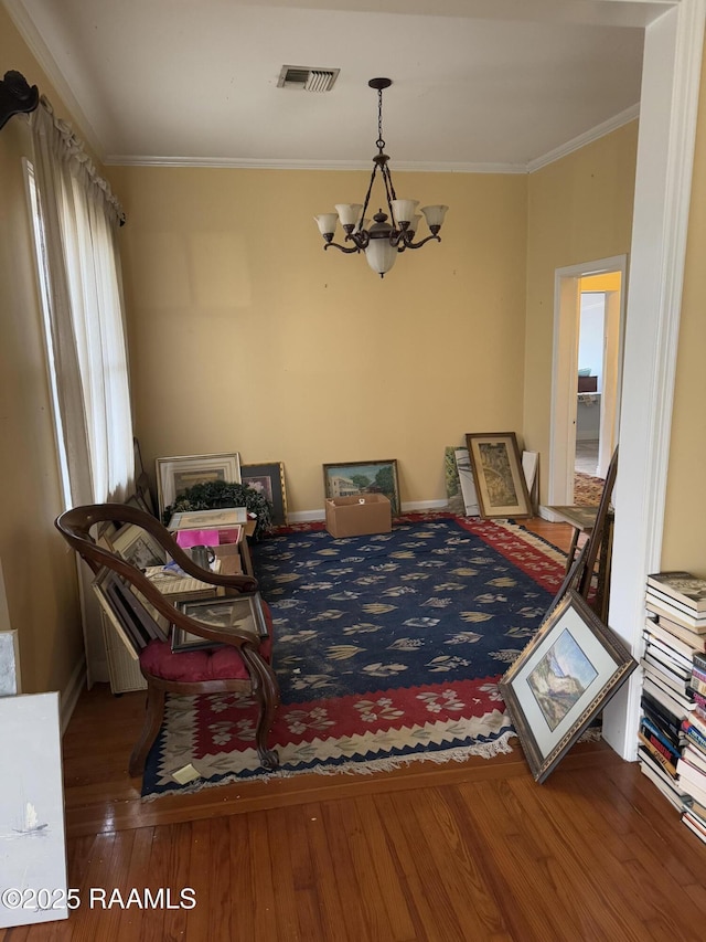 dining area featuring hardwood / wood-style flooring, crown molding, and a notable chandelier