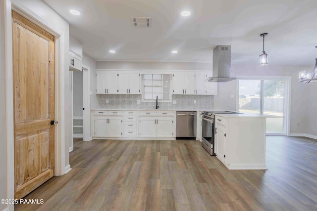 kitchen with sink, appliances with stainless steel finishes, white cabinetry, island exhaust hood, and decorative light fixtures