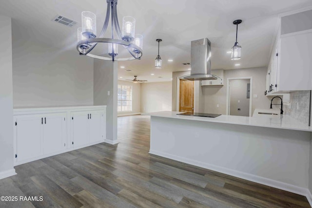 kitchen with dark wood-type flooring, sink, island range hood, black electric cooktop, and white cabinets