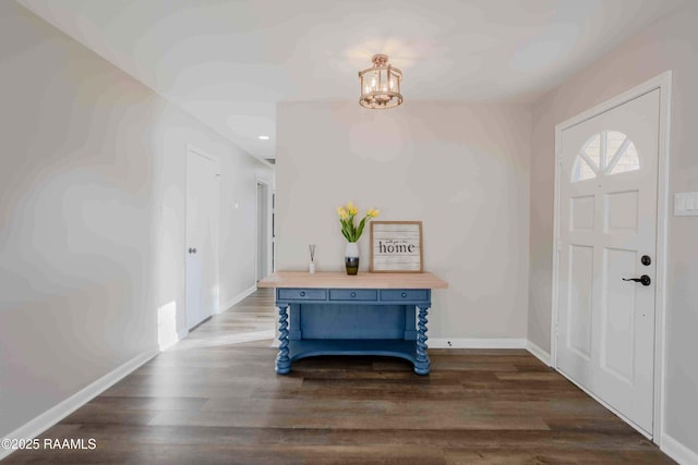 foyer entrance with dark hardwood / wood-style flooring and a chandelier