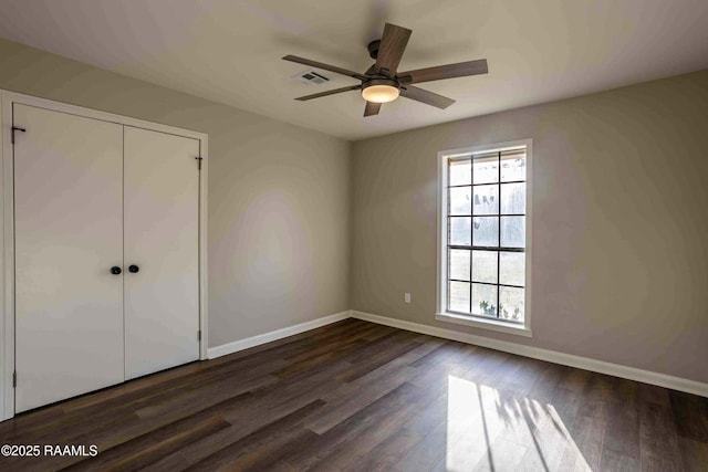 unfurnished bedroom featuring a closet, dark hardwood / wood-style floors, and ceiling fan