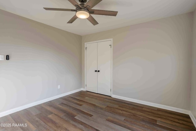 unfurnished room featuring dark wood-type flooring and ceiling fan