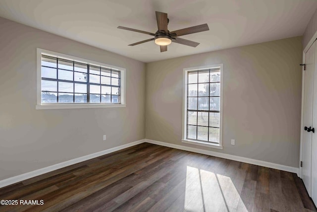 empty room featuring dark hardwood / wood-style floors, a wealth of natural light, and ceiling fan