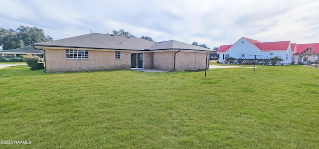 rear view of property featuring a lawn