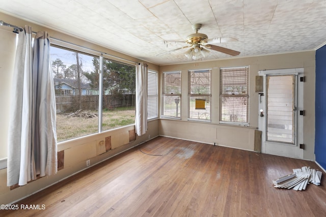 unfurnished sunroom featuring ceiling fan