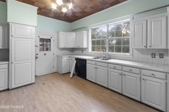 kitchen featuring dishwasher, sink, white cabinets, decorative backsplash, and light hardwood / wood-style floors