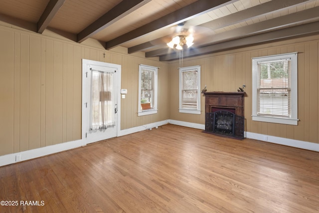 unfurnished living room featuring beamed ceiling, hardwood / wood-style floors, and wooden ceiling