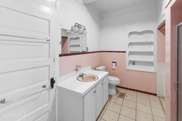 bathroom featuring tile patterned flooring, vanity, tile walls, and toilet