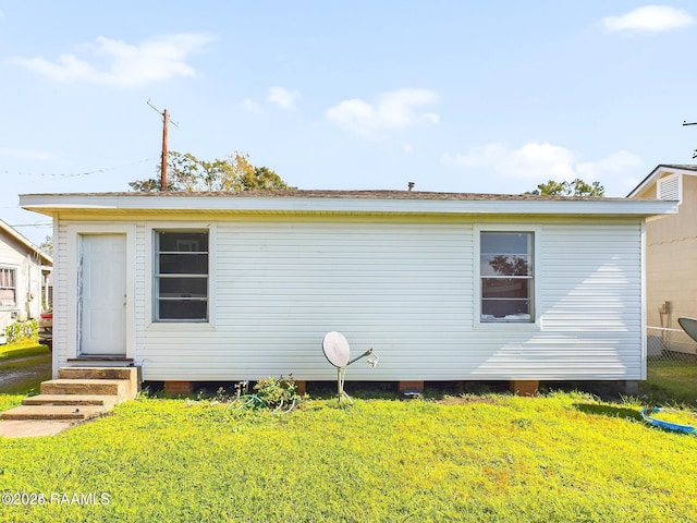 rear view of property with a yard