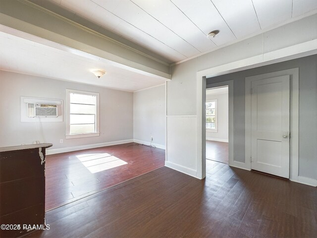 unfurnished room featuring ornamental molding, a wall mounted air conditioner, dark hardwood / wood-style floors, and plenty of natural light