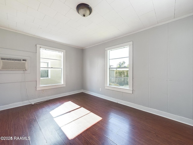 spare room with ornamental molding, dark hardwood / wood-style floors, and a wall mounted AC