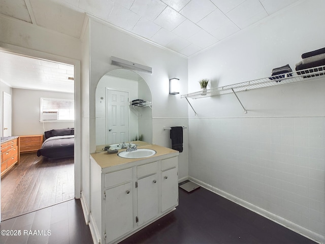 bathroom featuring ornamental molding, vanity, hardwood / wood-style floors, and tile walls