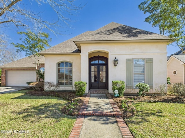 view of front of property with roof with shingles, stucco siding, a front lawn, french doors, and a garage