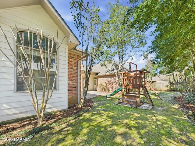 view of yard featuring fence and a playground