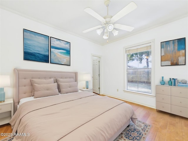 bedroom with light wood-style flooring, a ceiling fan, crown molding, and baseboards