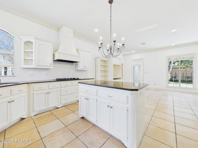 kitchen featuring dark countertops, premium range hood, backsplash, and ornamental molding