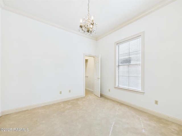 empty room featuring a notable chandelier, light colored carpet, baseboards, and ornamental molding