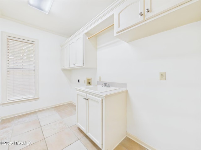 washroom with baseboards, hookup for an electric dryer, cabinet space, a sink, and washer hookup