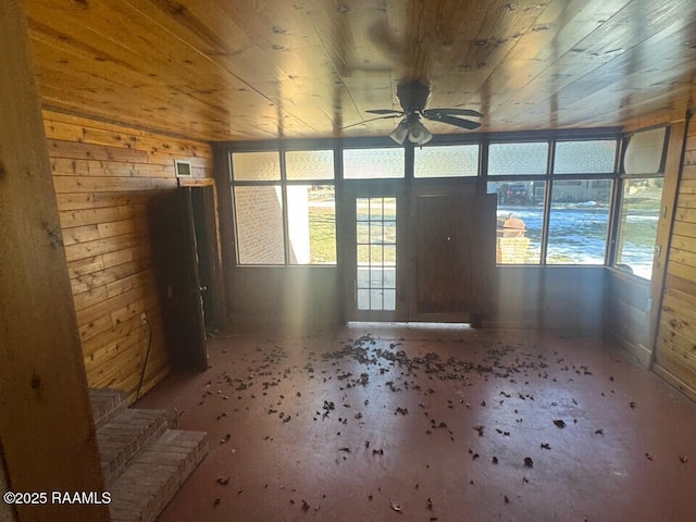 interior space featuring wooden ceiling, ceiling fan, and wood walls