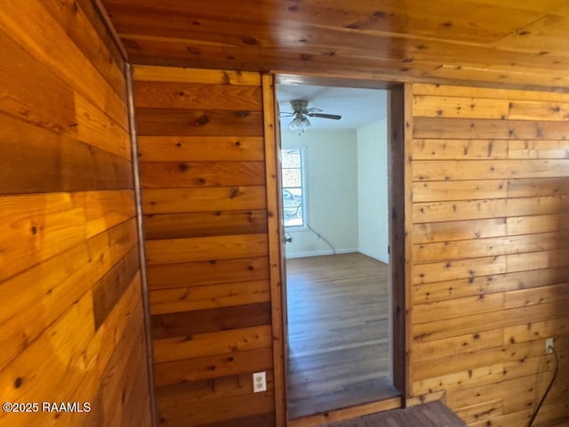 corridor featuring hardwood / wood-style flooring and wood walls