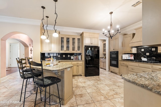 kitchen with a breakfast bar area, light stone counters, decorative light fixtures, decorative backsplash, and black appliances