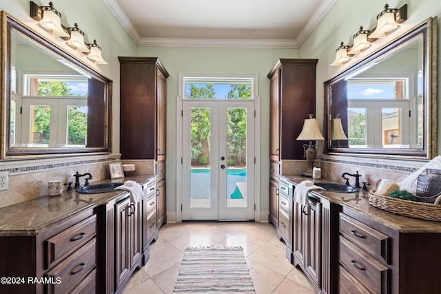 entryway with french doors, ornamental molding, sink, and light tile patterned floors