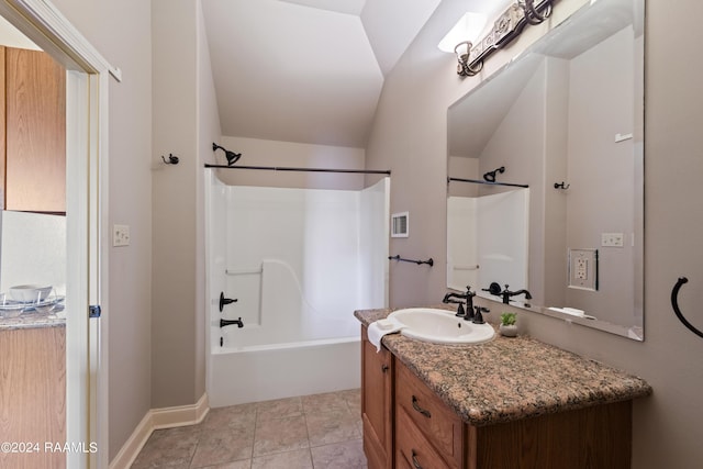 bathroom featuring tile patterned floors, vanity, washtub / shower combination, and lofted ceiling